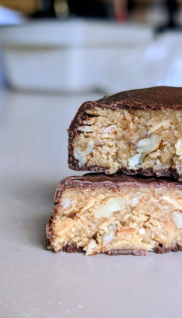 A chocolate-coated bar cut in half to show a nutty filling
