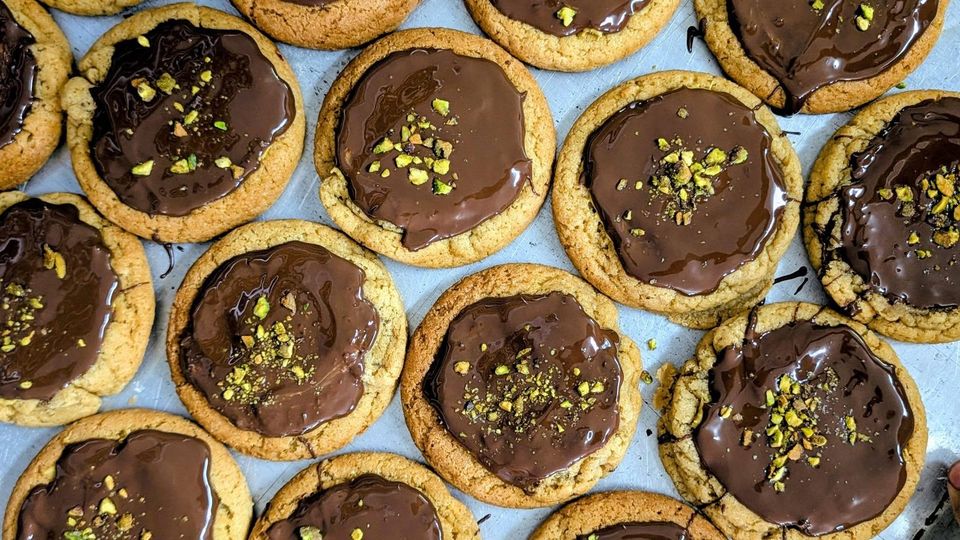 Round cookies topped with chocolate and a sprinkle of chopped nuts