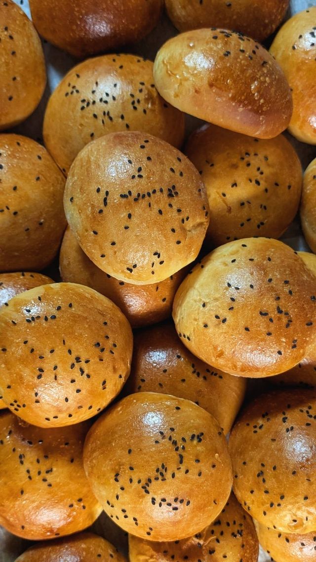 Shiny golden buns sprinkled with dark seeds