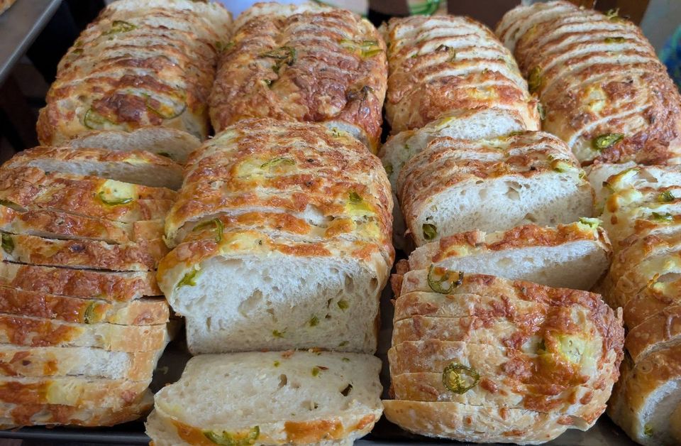 Sliced loaves with melted cheese and green pepper rings on top