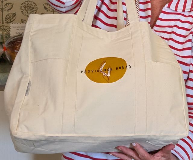 Cream canvas tote bag with the gold Providence Bread wheat logo